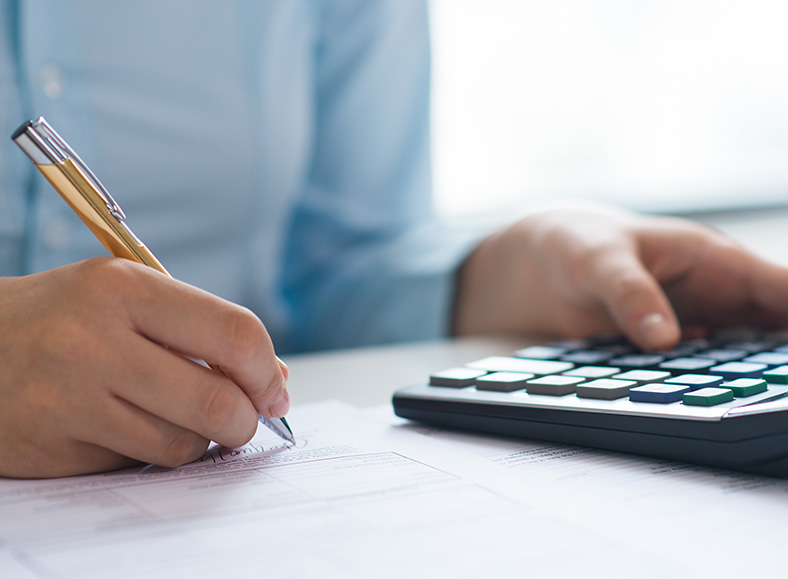 Como contabilizar a venda do ativo imobilizado - pessoa fazendo o cálculo com calculadora, caneta e papel