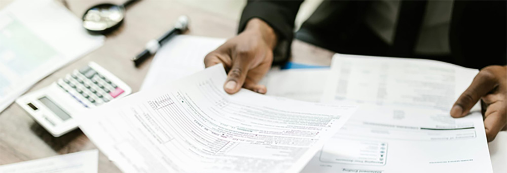 Profissional entregando documentos para implantação de normas e procedimentos dentro da Consultoria de Gestão do Imobilizado