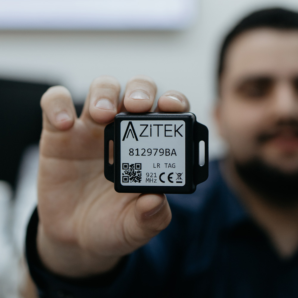 Profissional segurando tag RFID Azitek com QR code utilizada nas soluções tecnológicas da Afixcode para rastreamento de ativos
