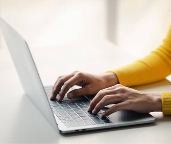 Pessoa digitando em notebook realizando atividades de inventário físico virtual em ambiente de trabalho